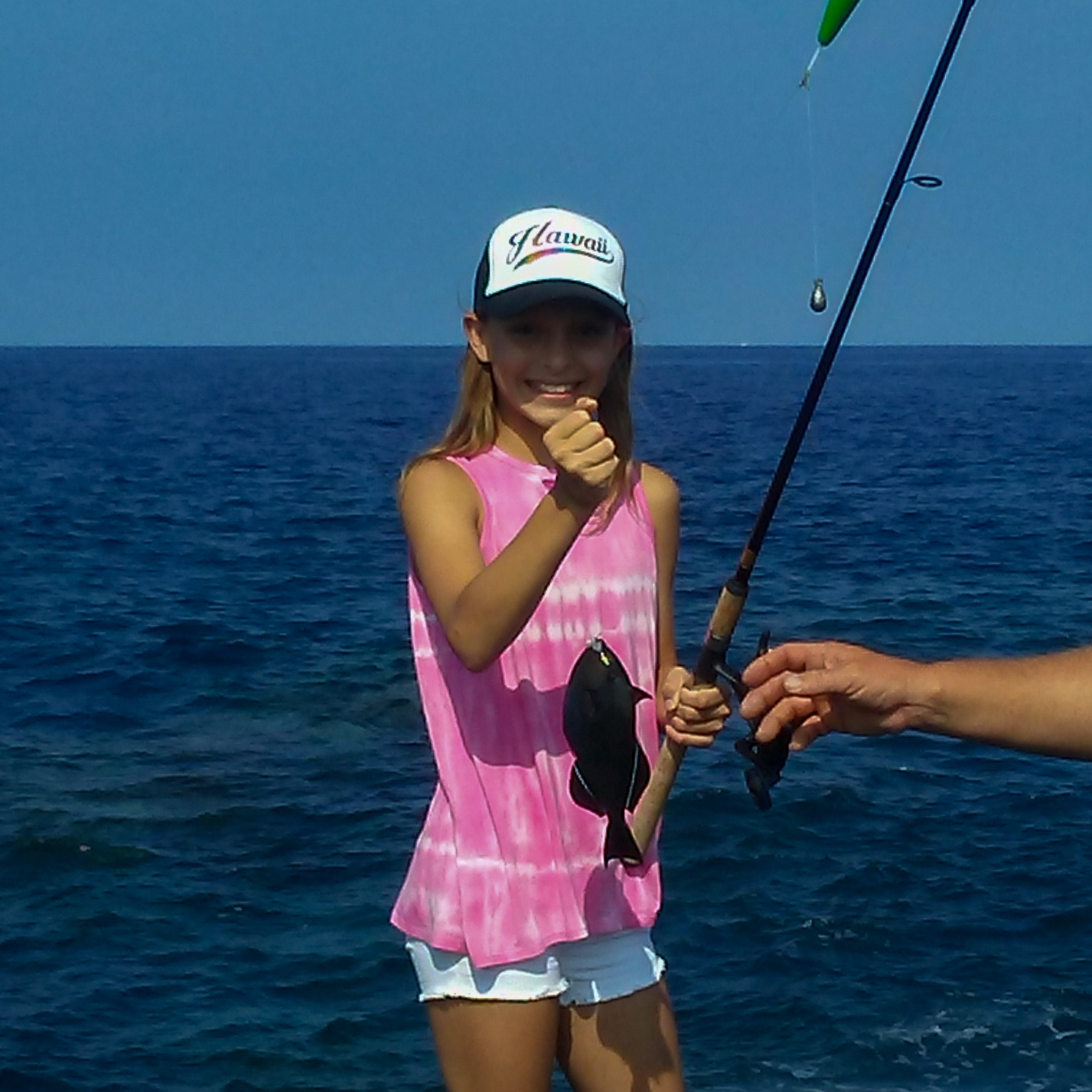 girl holding a fish at the ocean